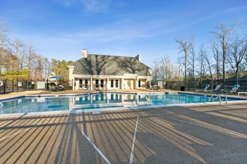 a swimming pool with a house in the background at Ashton Creek, Chester, Virginia